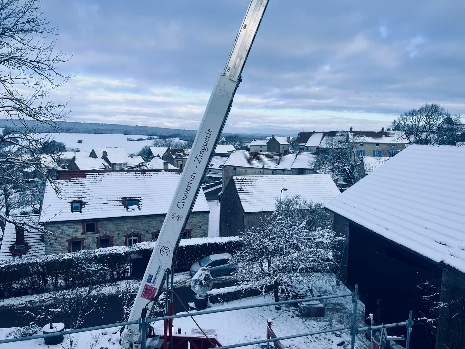 Chantier de toiture sous la neige, vue sur le village