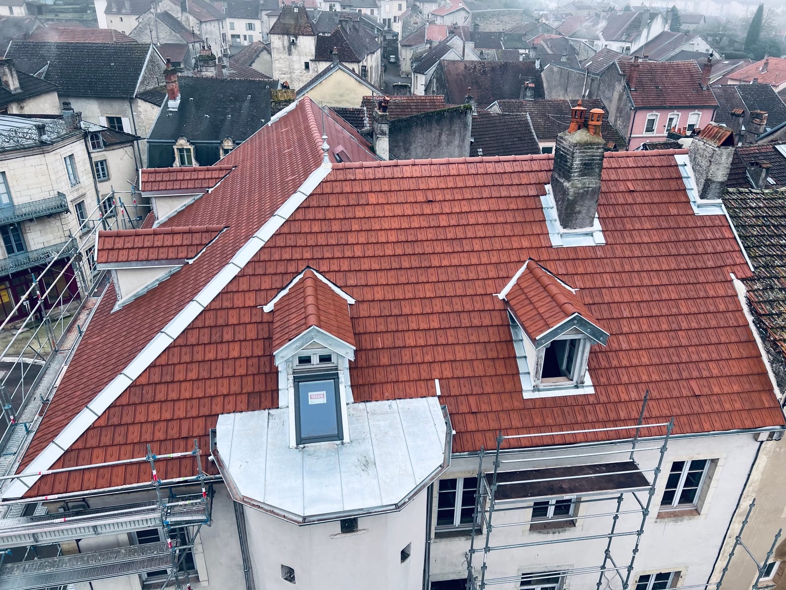 Toiture en tuile Montchanin losangée et tourelle en zinc joint debout de la Caisse d’Épargne de Jussey (Haute-Saône), rénovées par MS Couverture Zinguerie